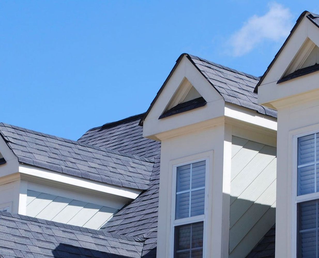 A residential roof with dormer gables, the kind Summit View Roofing replaces after Colorado hail and wind storms